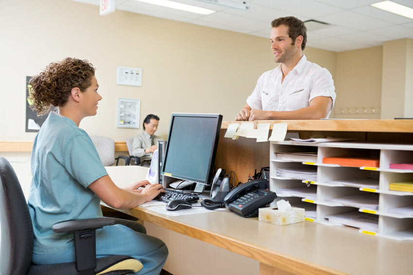 Doctor explain medical billing collection process to front desk associate